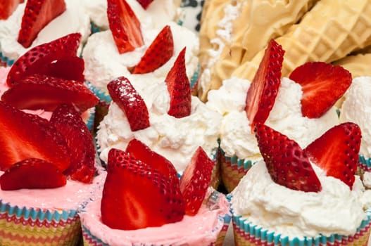 Delicious vanilla cupcake with strawberry frosting and fresh strawberries