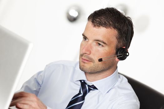 man working with headset and computer in office