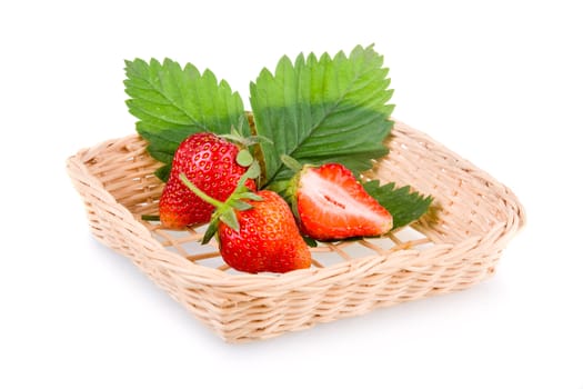 Basket of red strawberry fruits with green leaves isolated on white background 