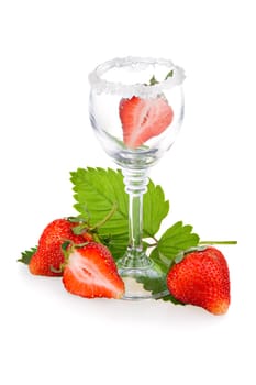 Red strawberry fruits with green leaves in glass isolated on white background