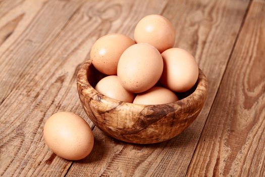 fresh brown eggs on wooden background