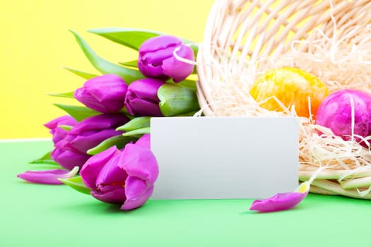 Bouquet of tulips with blank card and Easter eggs