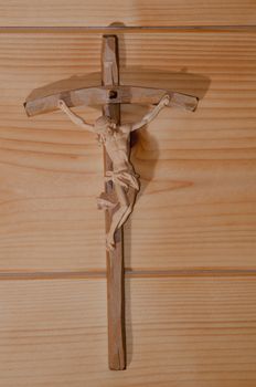 Wooden cross on a wooden wall in a cozy alpine cottage