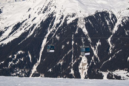 cabins of a cable car lift in front of mountains in Montafon, Austria
