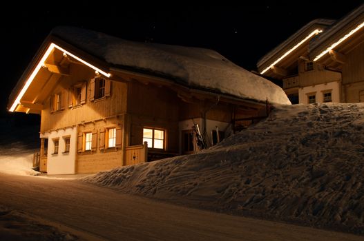 Wooden skiing huts covered with a lot of fresh snow at night in Montafon, Austria