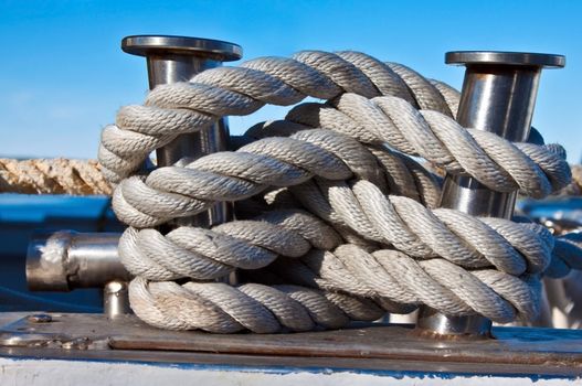 Bundle of rope on the silver mooring bollard on deck