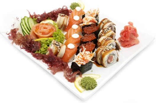 plate of sushi beautifully decorated with salad and fruit on a white background