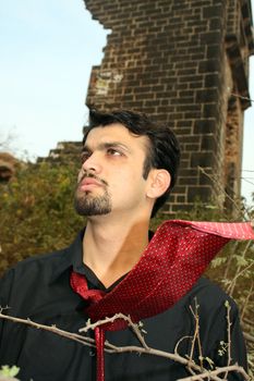 A portrait of a young Indian visionary businessman, in the outdoors.