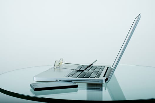 Workplace modern computer and acessories on a glass table in the office close up