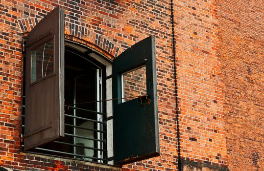 Window with shutters on brick wall