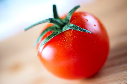 Red cherry tomato on a cutting board close up