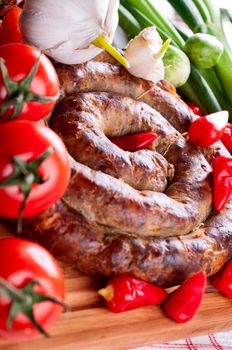 Sausage with spices, tomatoes and red pepper close up