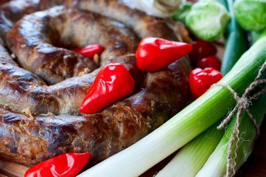Sausage with onions and red pepper close up