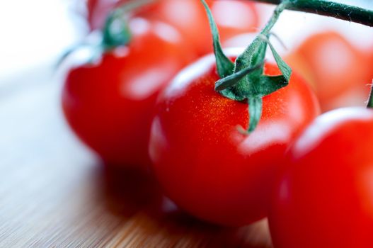 Red cherry tomatoes on a cutting board close up