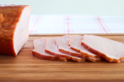 Ham cut into slices on a wooden board