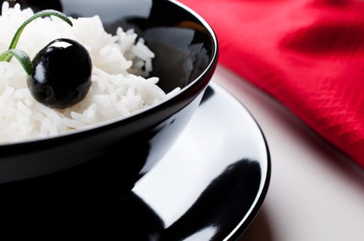 White rice in black bowl on red tablecloth