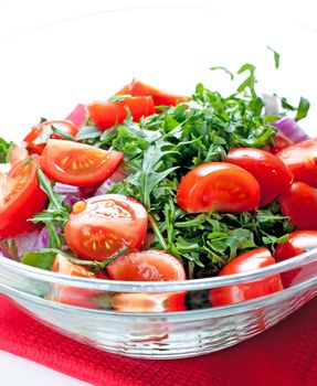 Tomato salad with ruccola and onion close up