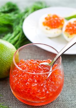 Salmon caviar in glasses on dill and lime background