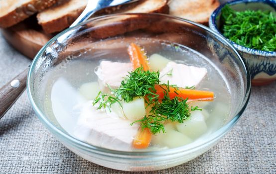 Salmon soup with vegetable in glass bowl