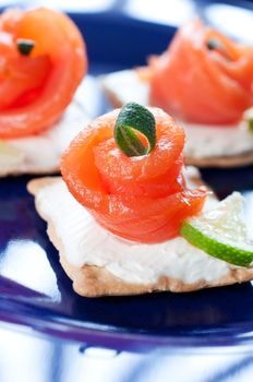 Canapes with smoked salmon on dark blue plate