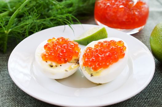 Eggs and caviar on white saucer close up
