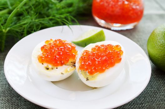 Eggs and caviar on white dish close up