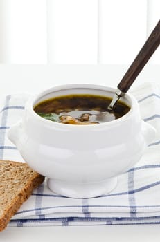 Mushroom soup in white bowl with bread