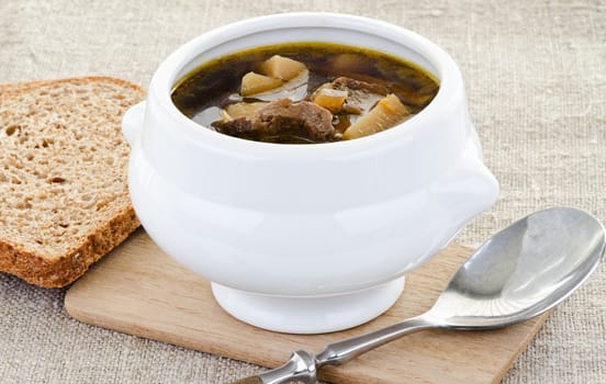Mushroom soup in white bowl with bread