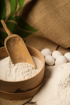 A bowl of flour and white eggs prepared for baking