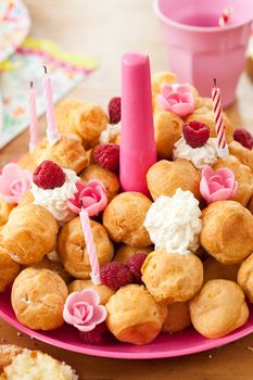 Birthday plate with a tower of puff cakes and whipped cream
