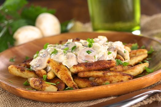 Schupfnudeln (Swabian potato noodles from Southern Germany) with mushroom sauce (Selective Focus, Focus on the front of the mushroom sauce) 