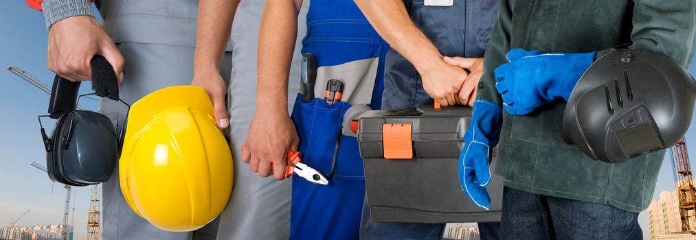 workers closeup with equipment on building background