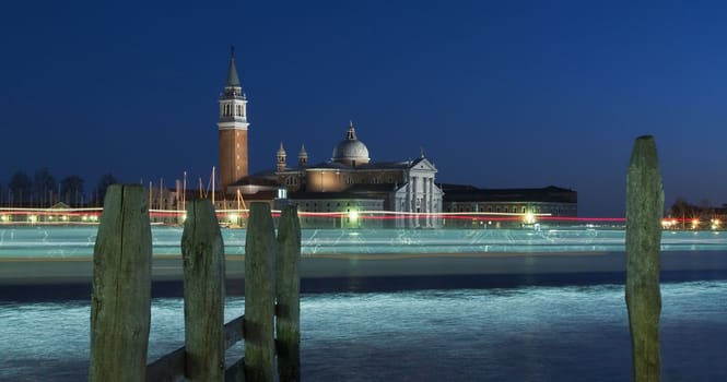 View on the island of San Giorgio in Venice in the winter night with the lights of passing ships traces
