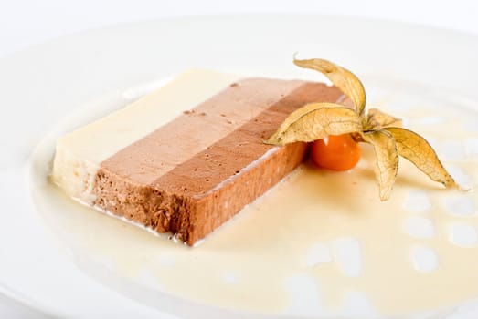 dessert from three different kind of chocolate with ground-cherry closeup on a white
