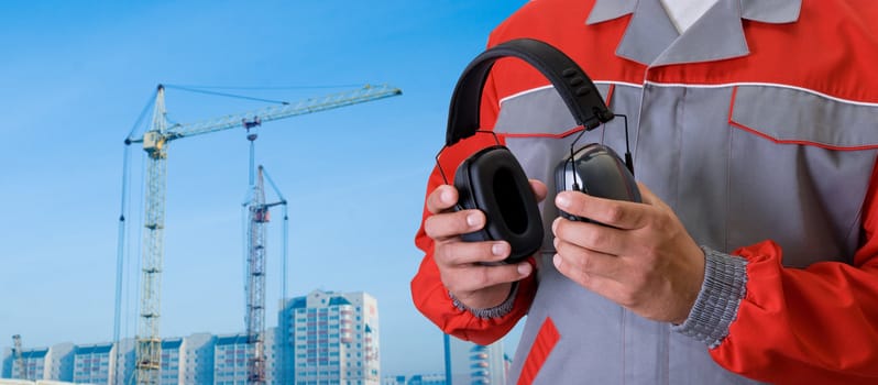 protective headphone at man hands on building background