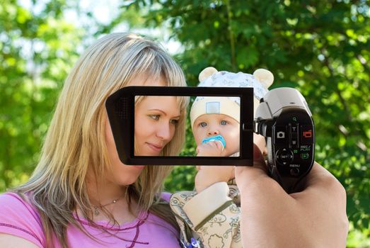 happy mum and her boy outdoor portrait at camcorder