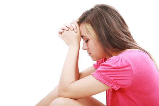 Young woman praying sincerely with her hands folded and eyes closed