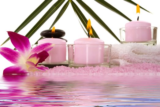 Orchids, towel, candles, pebbles and aromatic bath salt in a spa