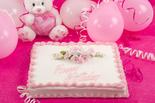 Delicious beautifully decorated bithday cake, teddy bear and balloons