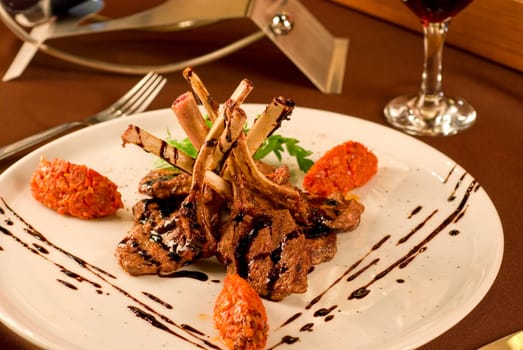 Roasted lamb chops with vegetables on decorated table