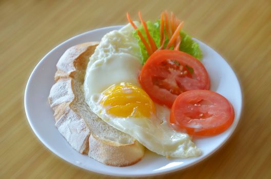 american style breakfast , with toast,  fried egg and fresh vegetables