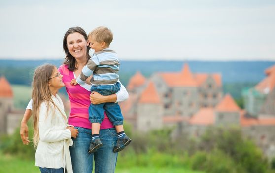 Travelers. Happy famyli of three on a tour of European medieval castles.