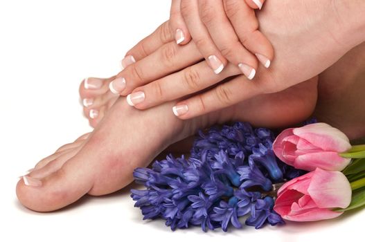 Pedicured feet, manicured hands and aromatic flowers in a spa