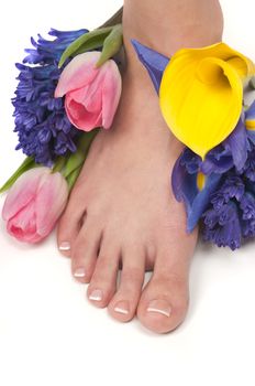 Pedicured feet, manicured hands and aromatic flowers in a spa