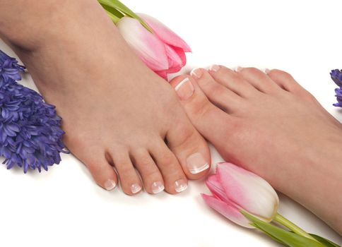 Mother and daughter having spa treatment ( pedicured feet and aromatic flowers)