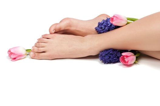 Pedicured feet and aromatic flowers in a spa
