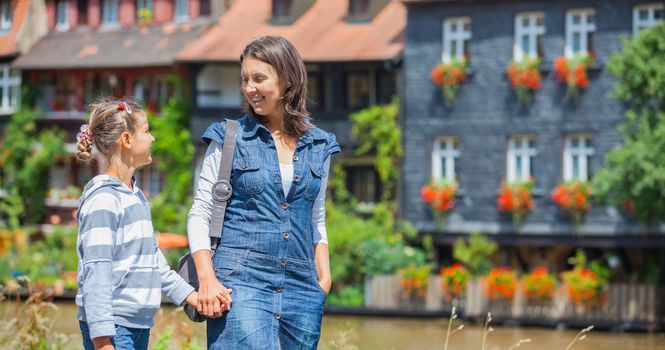 Tourists. Beautiful mother and daughter walking in europe city.