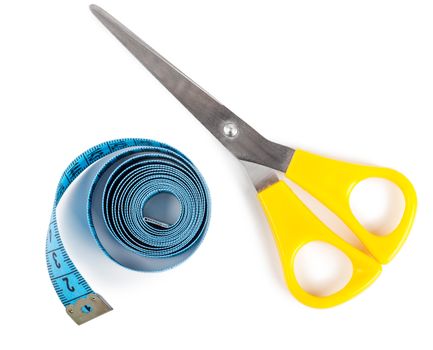 Closeup view of blue measuring tape and scissors over white background