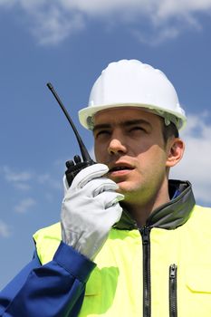portrait of builder talking in  transmitter on building site