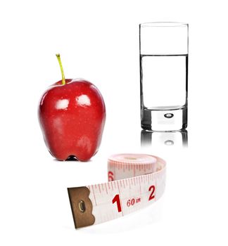 Healthy lifestyle - apple glass of water and tape measure on white background
